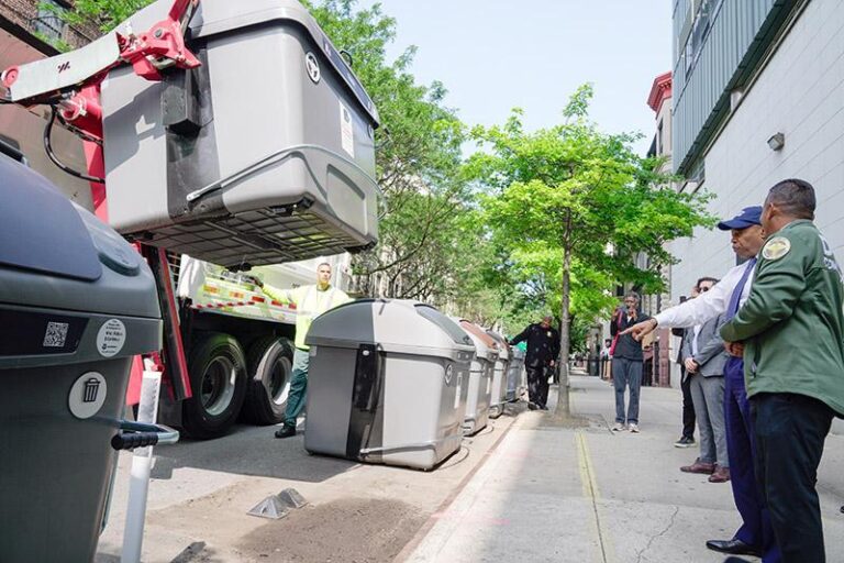 NYC DSNY truck lifting an Empire Bin during automated trash collection
